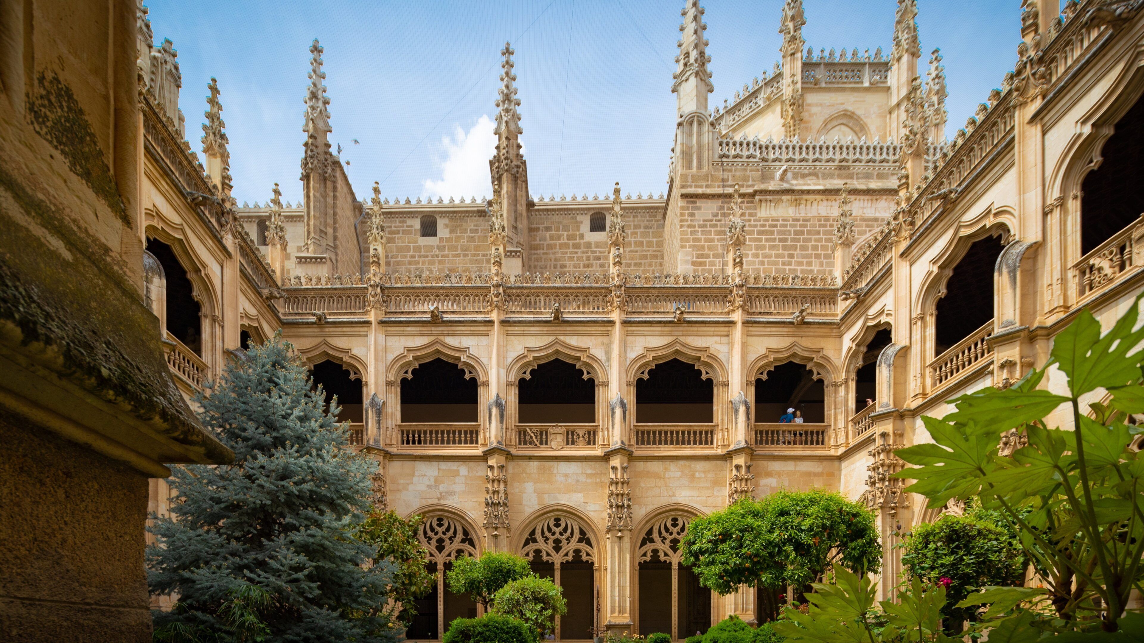 A grand Gothic-style courtyard with ornate arches and a central tower.