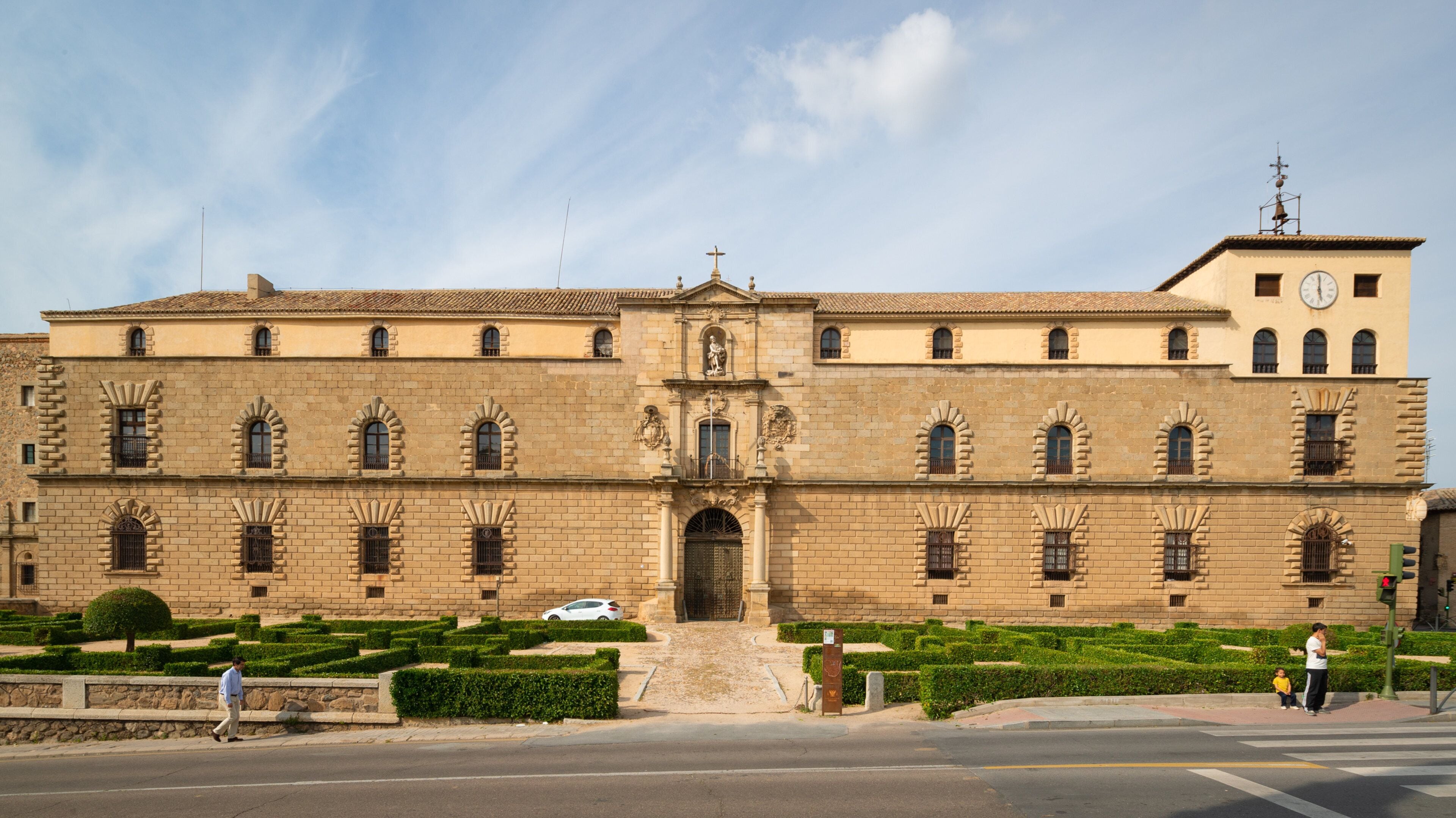 A large historic building with a clock tower, arched windows, and a central entrance.