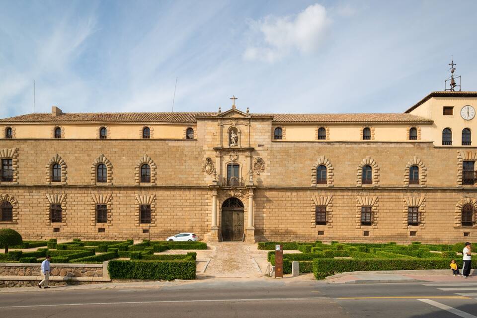 A large historic building with a clock tower, arched windows, and a central entrance.