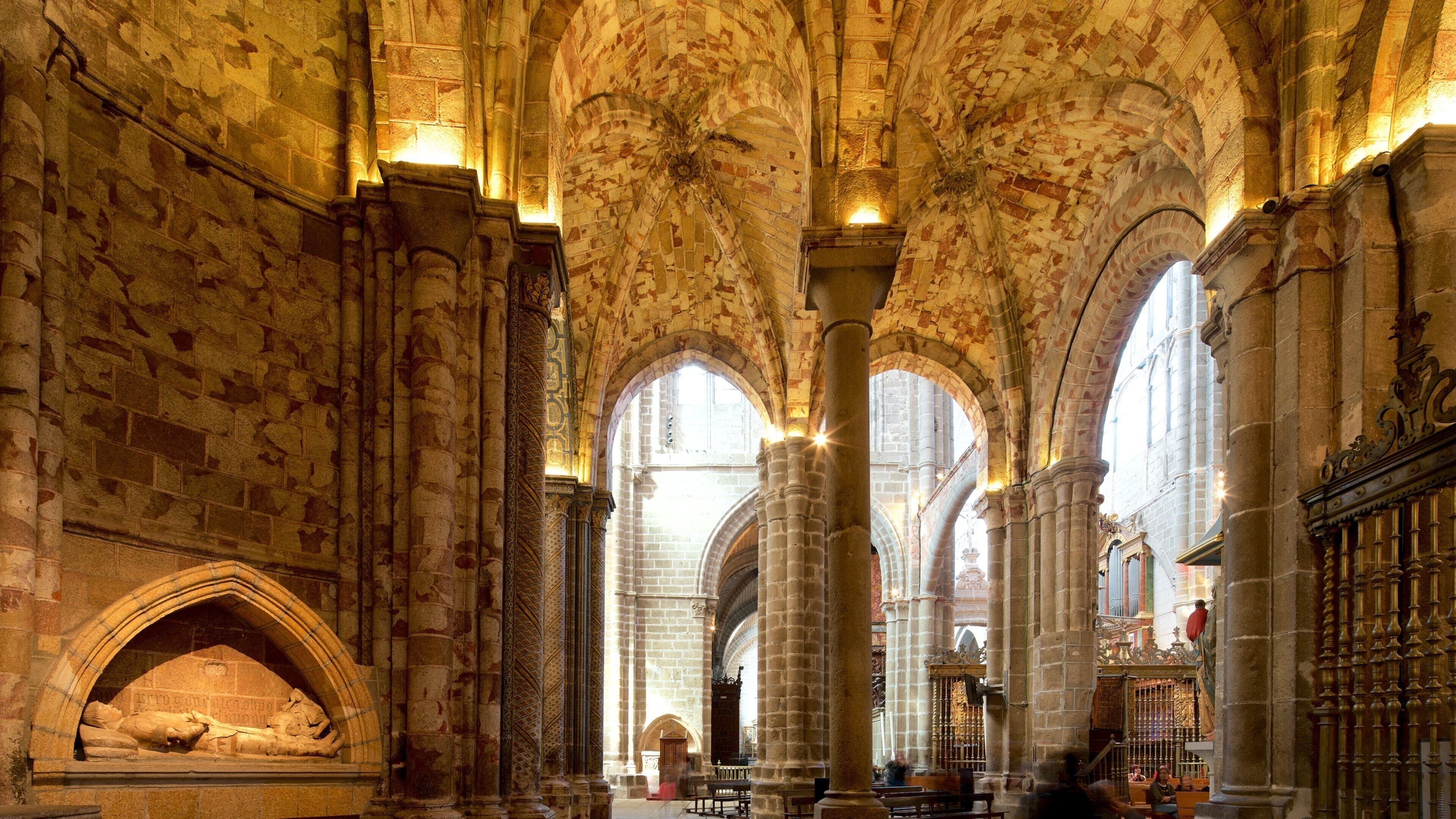 An interior of a cathedral with high vaulted ceilings, large stone columns, and arched windows.