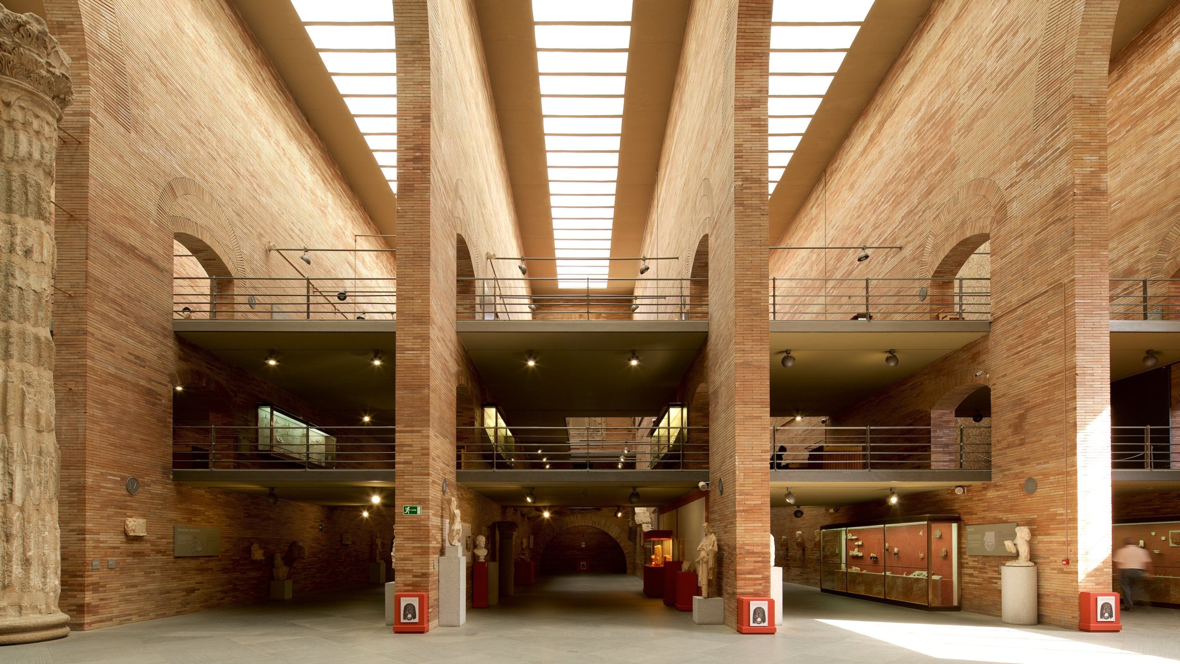 A spacious interior with high ceilings, exposed brick walls, and multiple levels with balconies.