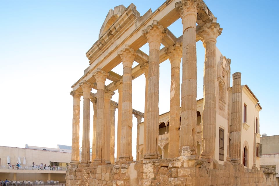 Ruinas griegas antiguas con columnas y una edificación parcialmente conservada.