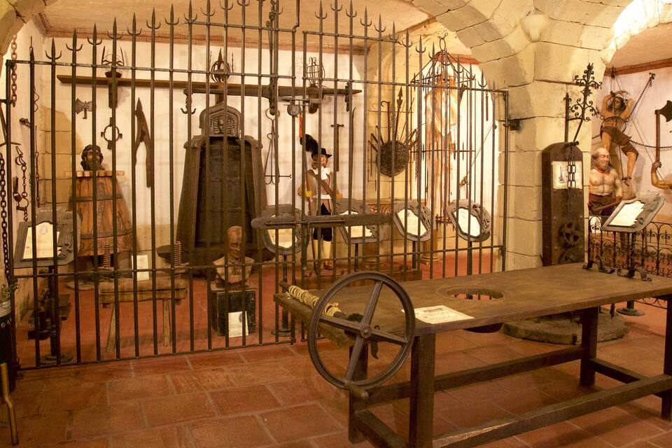 An old jail cell with iron bars and a wooden table.