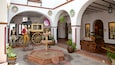 Ein Museum mit historischen Ausstellungsstücken, darunter eine Kutsche, ein Brunnen und Statuen.