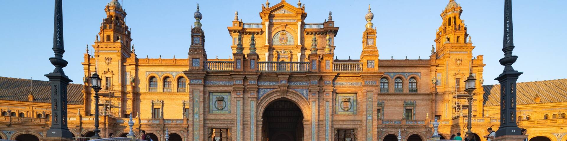 Un edificio histórico con arquitectura ornamentada, un arco central y dos puentes sobre un canal.