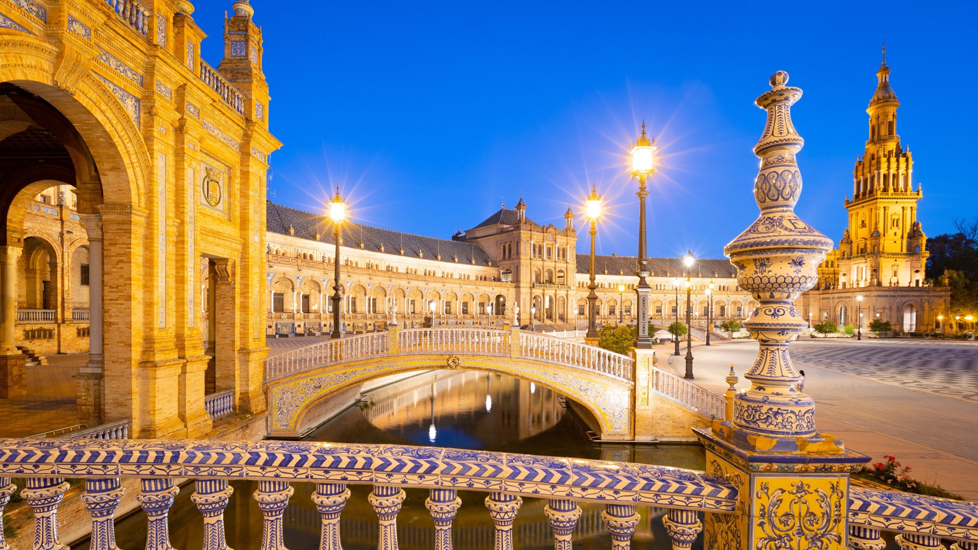 Une place historique, ornée de bâtiments élégants, avec un pont et une fontaine.
