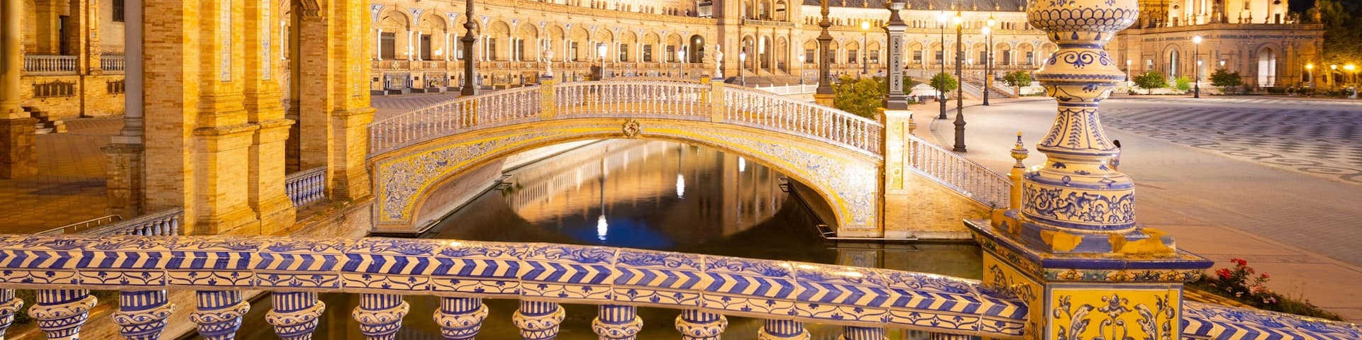 A historic square with ornate buildings, a bridge, and a fountain.