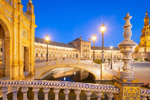 Une place historique, ornée de bâtiments élégants, avec un pont et une fontaine.