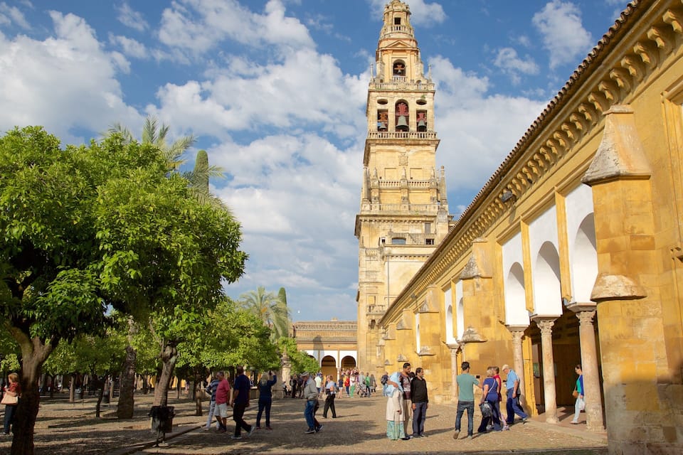 Una plaça històrica amb una torre imponent i arcs.