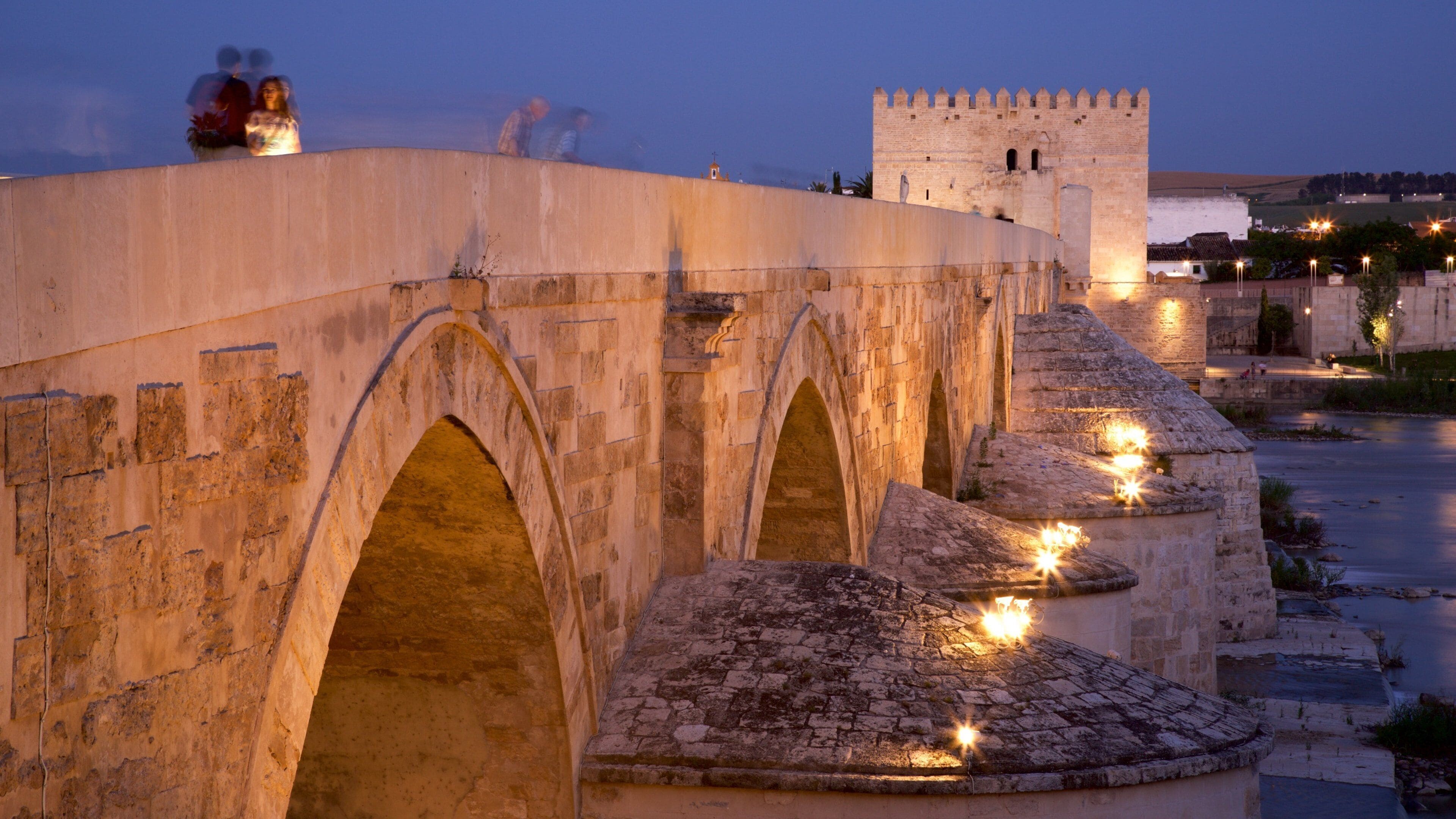 Roman Bridge which includes night scenes, heritage elements and a bridge