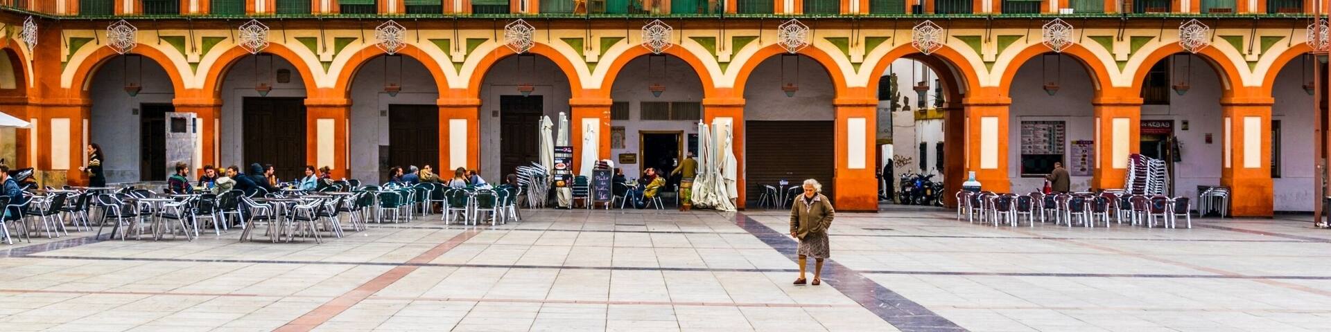 people are enjoying sunny day while drinking coffee on the plaza de la corredera in the spanish city cordoba