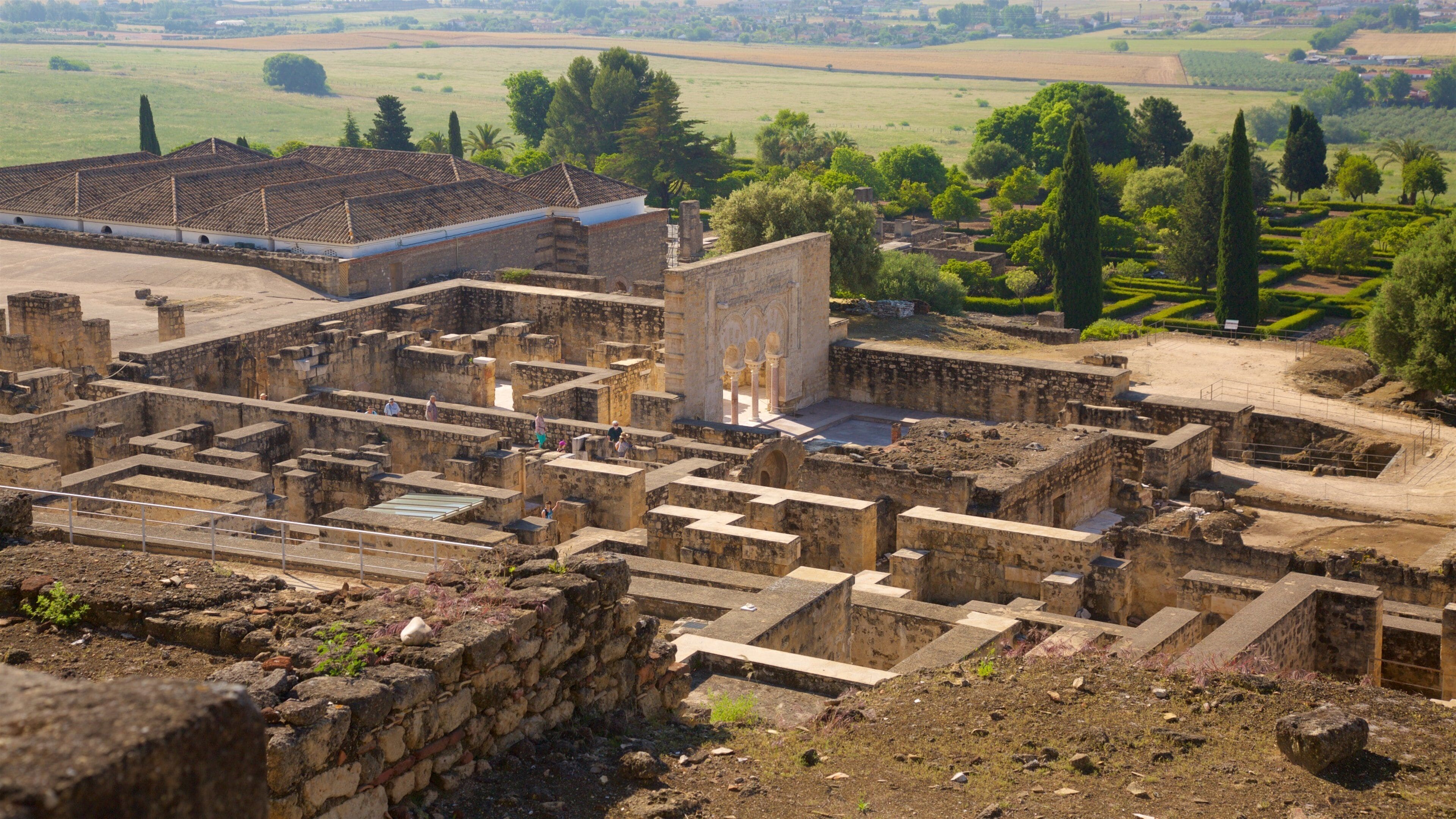 An ancient archaeological site with ruins and a large building with columns.