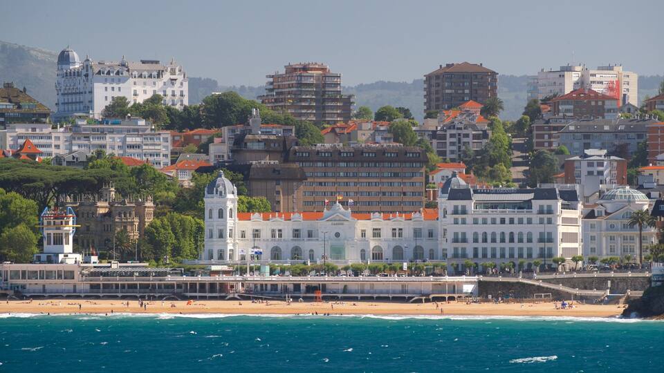 Paisatge marítim amb un edifici blanc destacat que té una cúpula, una platja i vista al mar.