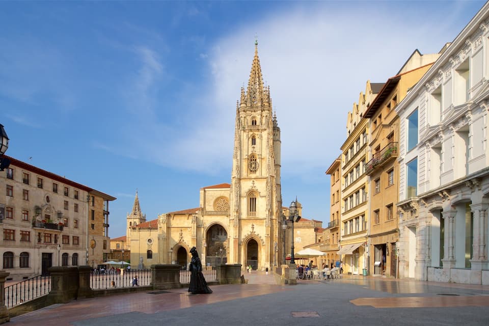 A historic square with a prominent cathedral featuring a tall spire and intricate architecture.