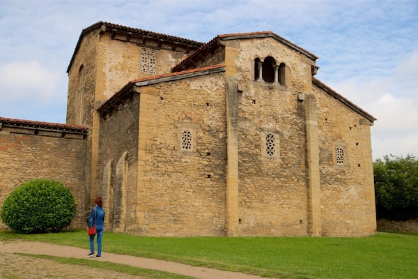 San Julián de los Prados welches beinhaltet historische Architektur sowie einzelne Frau