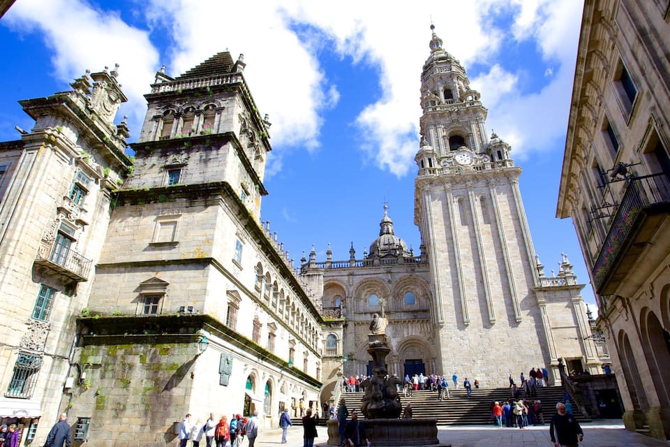 A historic square with a prominent cathedral featuring a tall bell tower and intricate architecture.