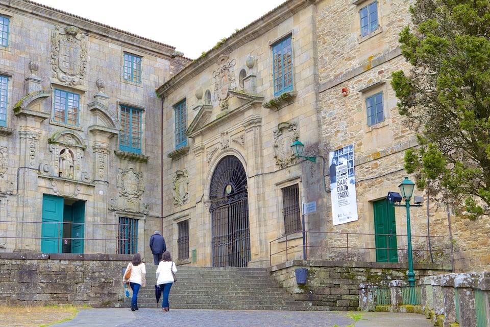 A historic stone building with ornate carvings and green shutters.