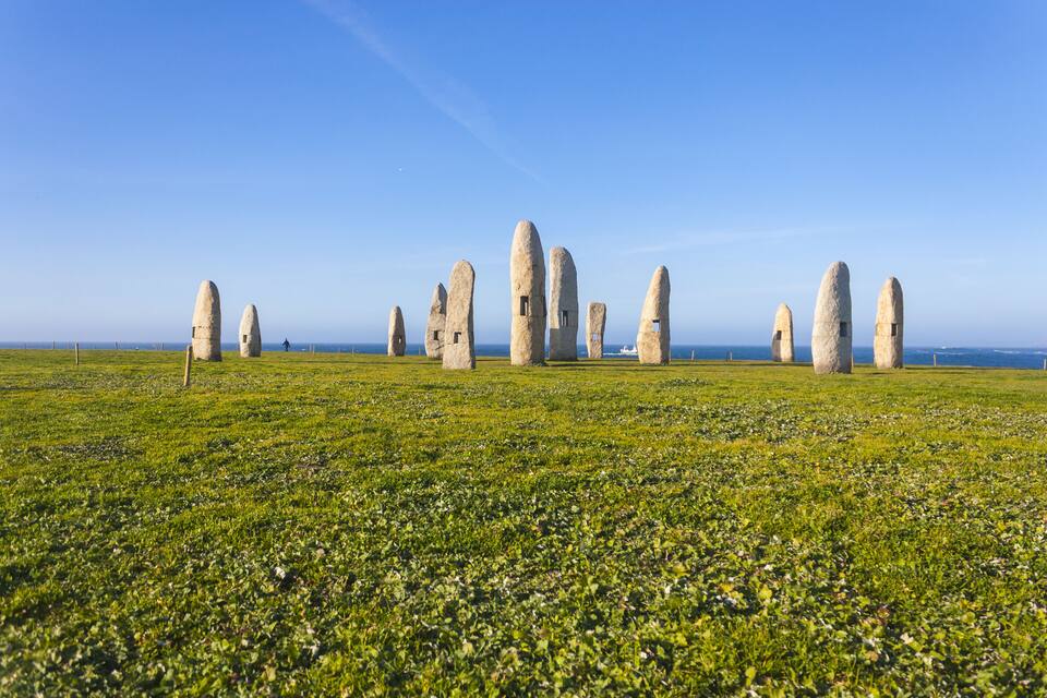 A field of standing stones under a clear blue sky.