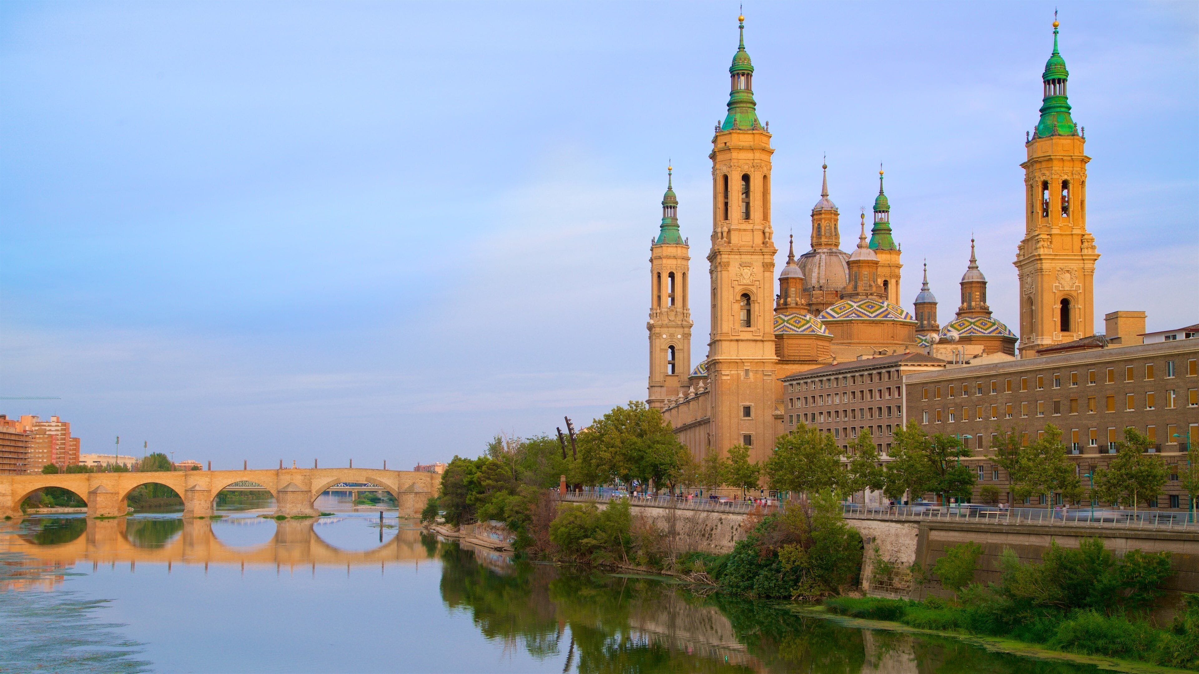 Eine historische Kathedrale mit mehreren Türmen und Kuppeln, eine Brücke und ein Fluss.