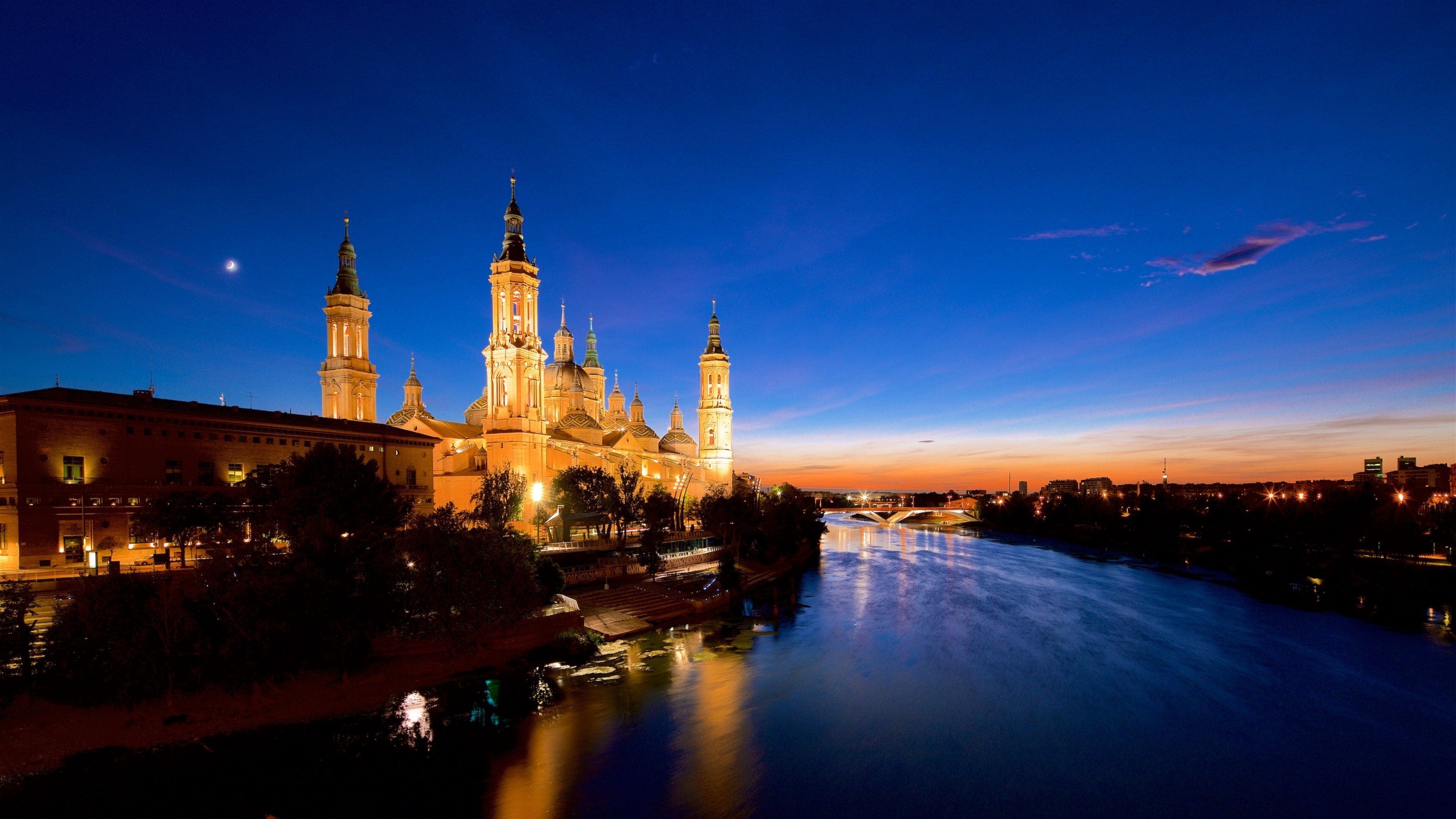 Basilica de Nuestra Senora del Pilar which includes heritage architecture, a sunset and a river or creek