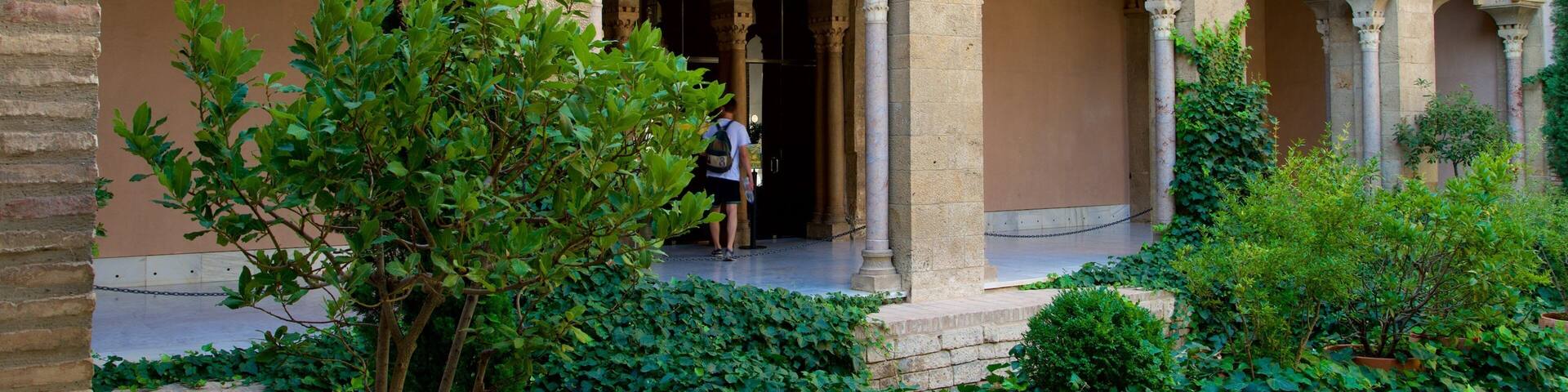 A courtyard with ornate arches and lush greenery.