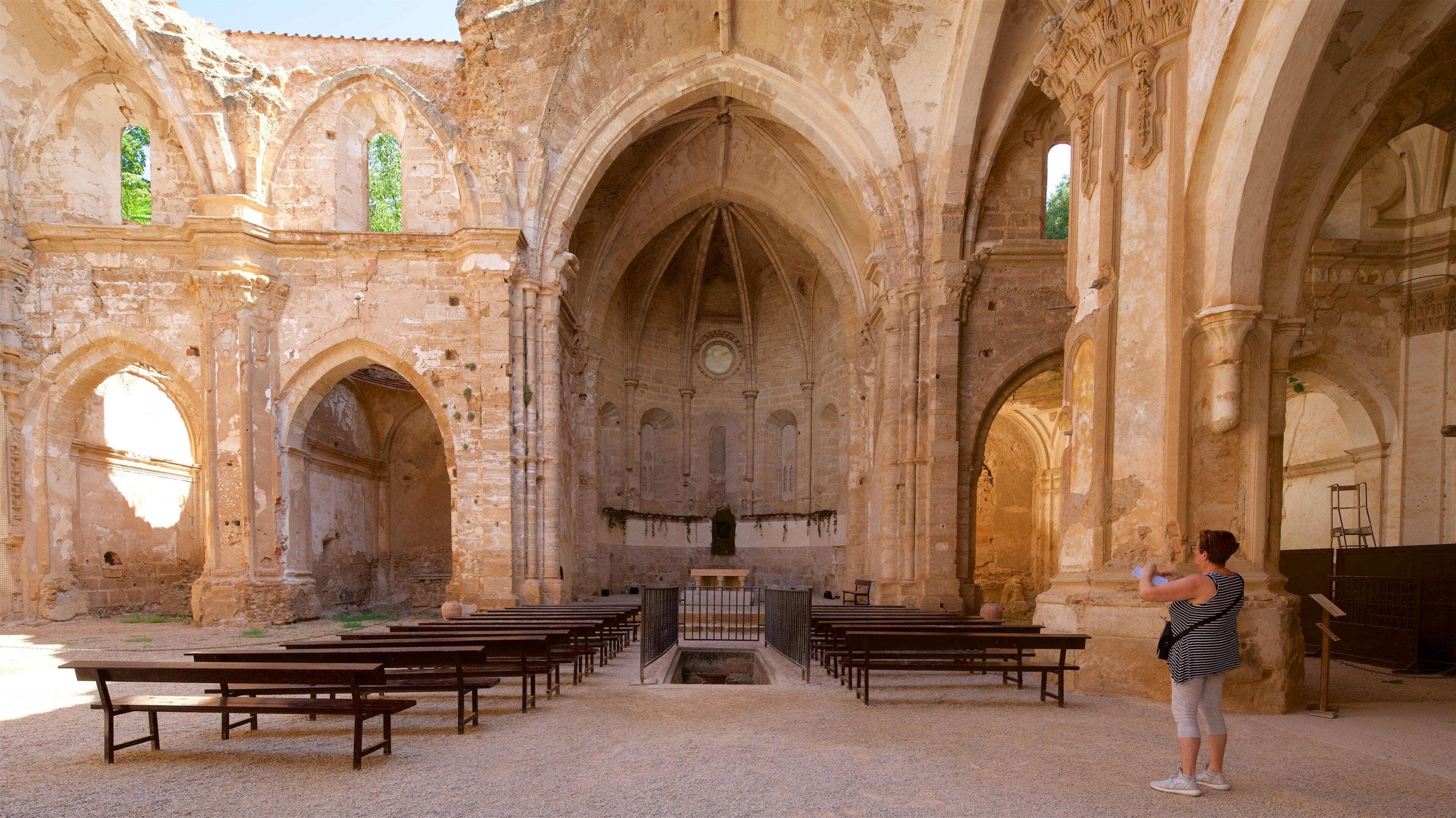 Una iglesia antigua con ventanas arqueadas y un altar central.