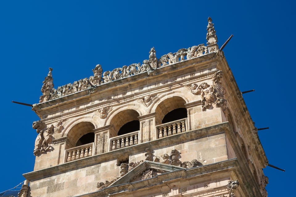 A historic building with ornate stone carvings and three arched windows.