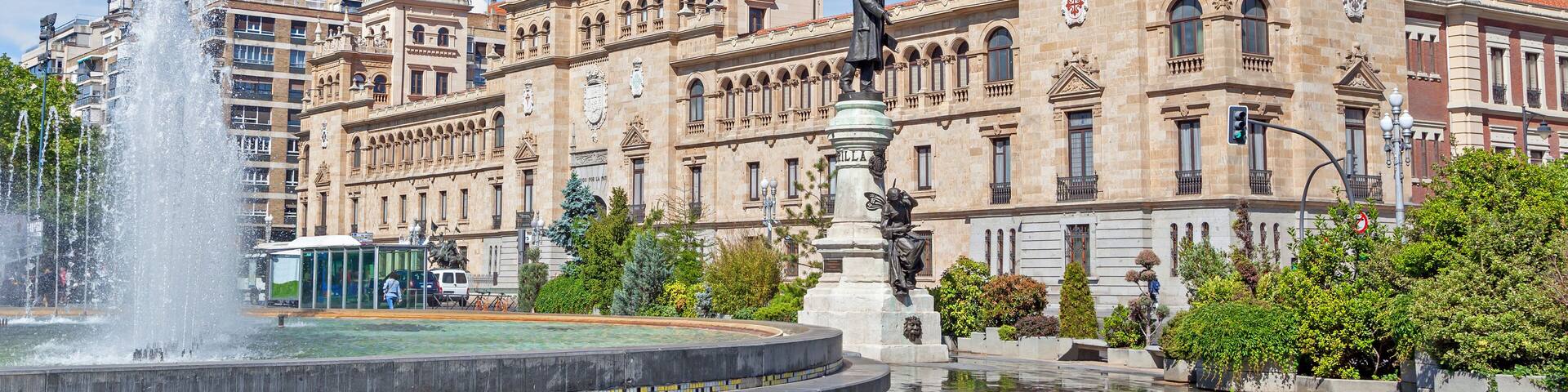 Un bâtiment historique avec une fontaine et des statues devant.