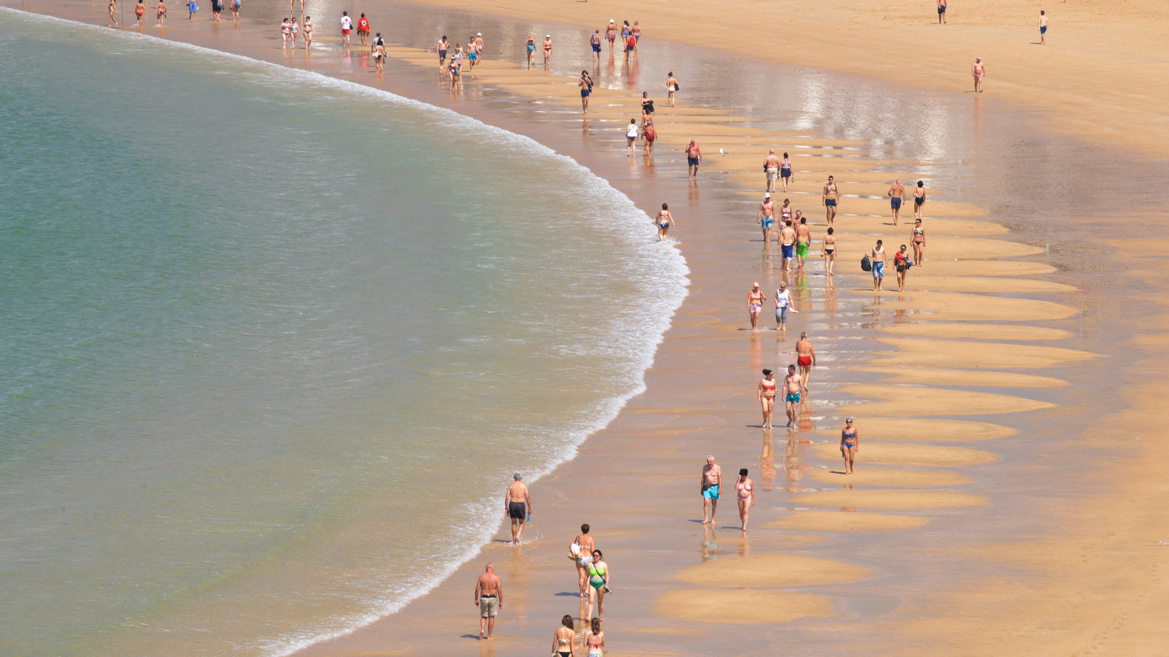 Concha Beach showing general coastal views and a sandy beach as well as a small group of people