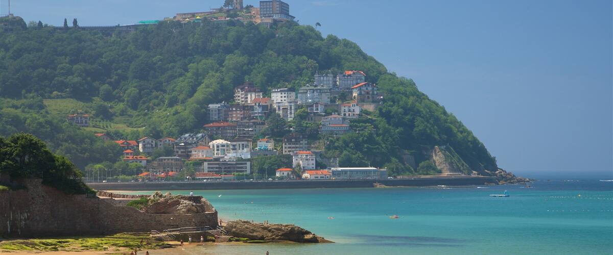 Concha Beach which includes a beach, a coastal town and general coastal views