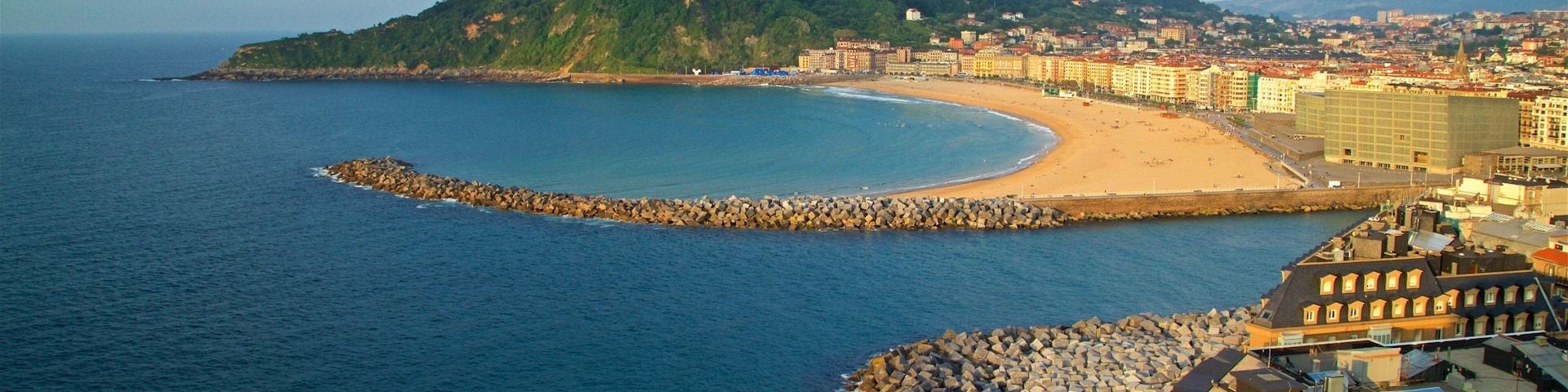 Monte Urgull which includes a coastal town, a beach and general coastal views