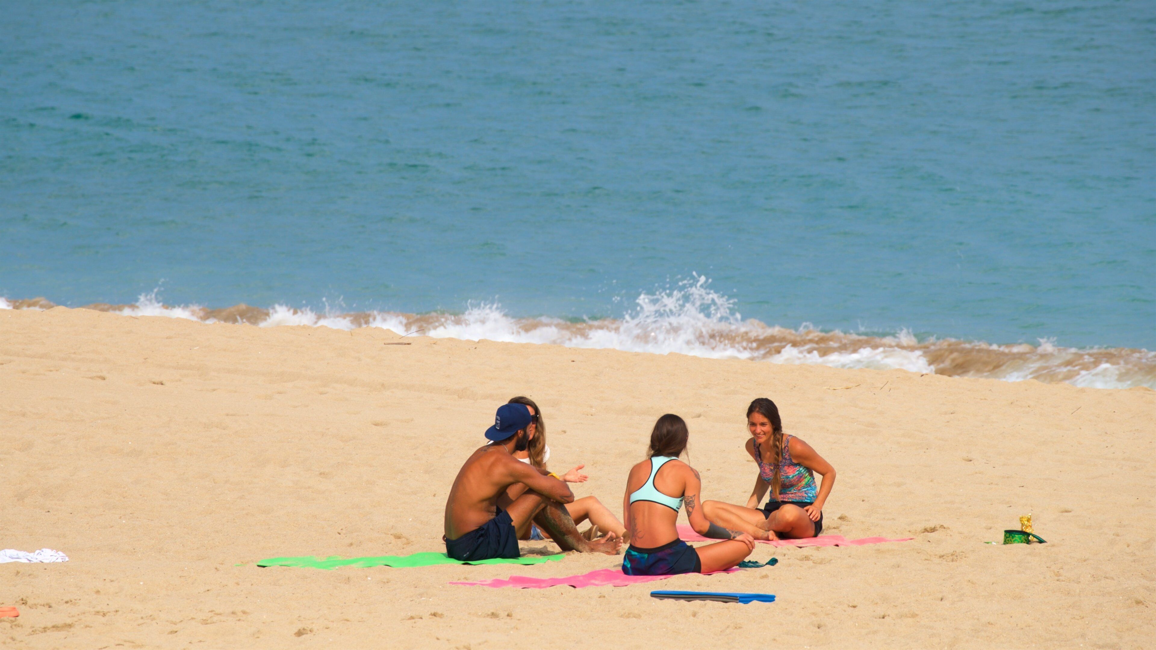Zurriola Beach featuring a sandy beach and general coastal views as well as a small group of people