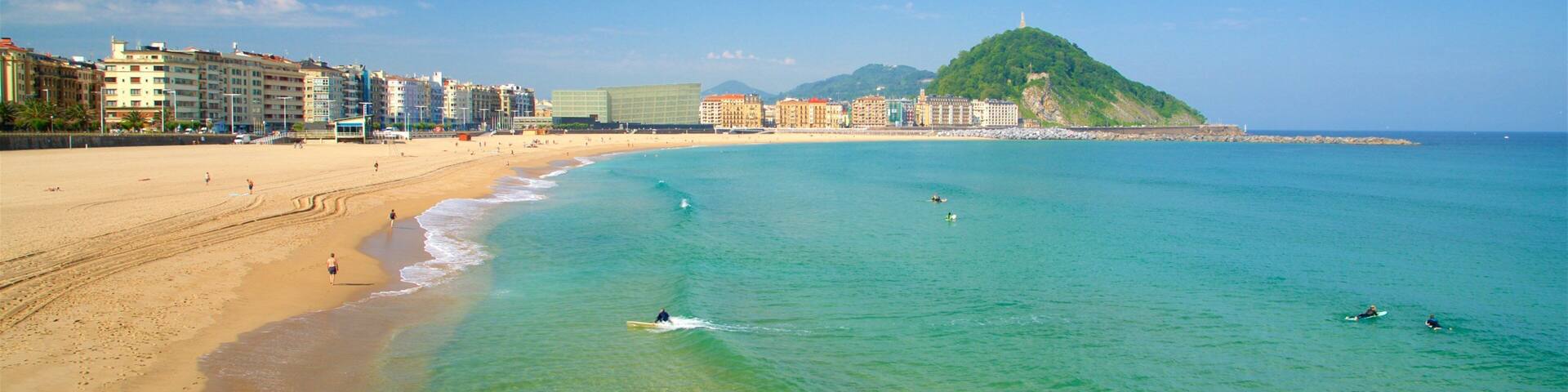 Zurriola Beach which includes general coastal views, surfing and a coastal town