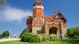 A large brick building with a tower and arched entrance.
