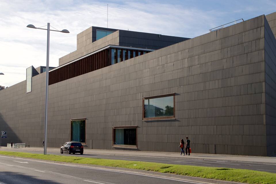 Een modern gebouw met een plat dak en grote ramen.