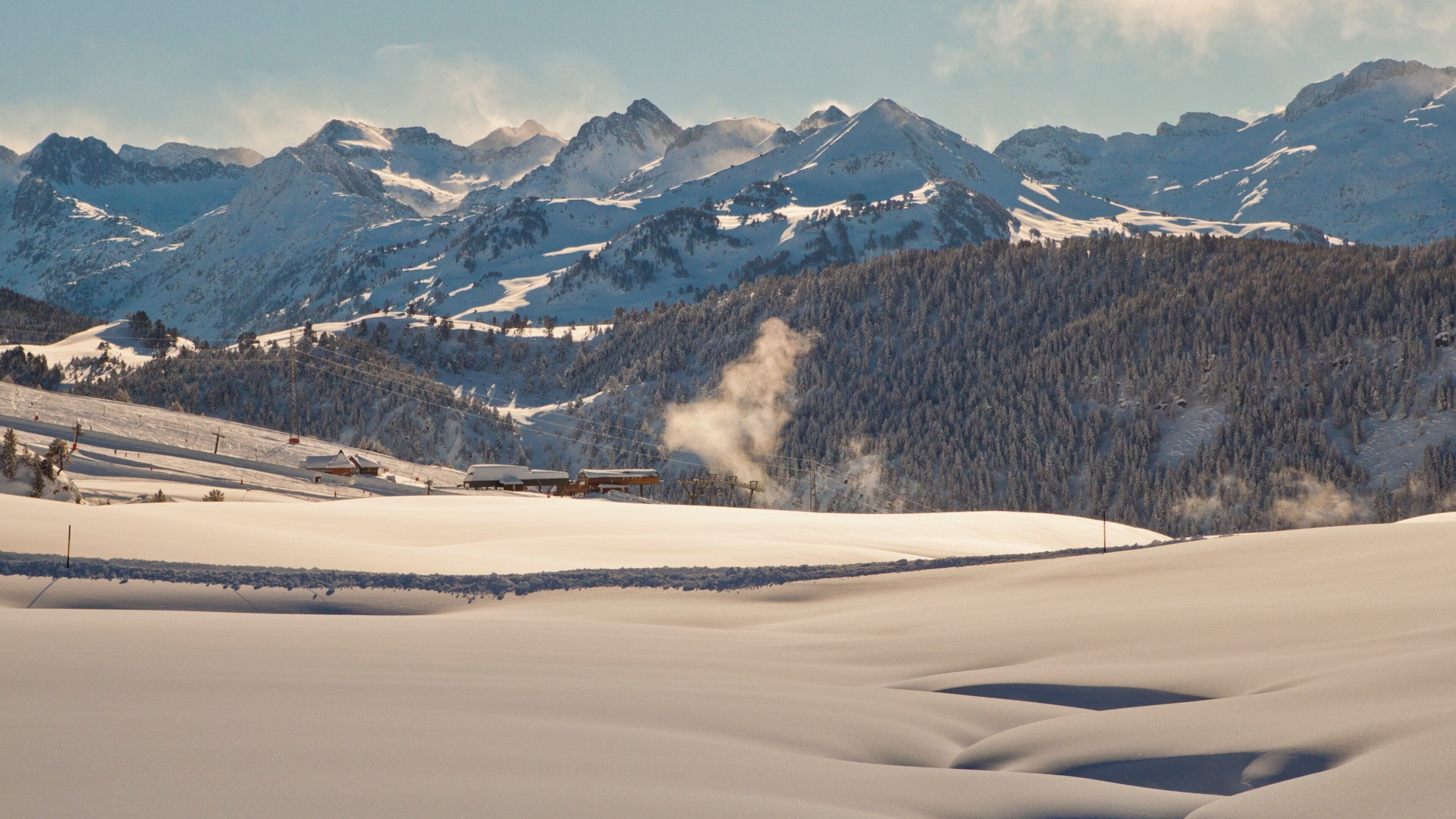A snowy mountain landscape with ski slopes, a ski lift, and a steam vent.