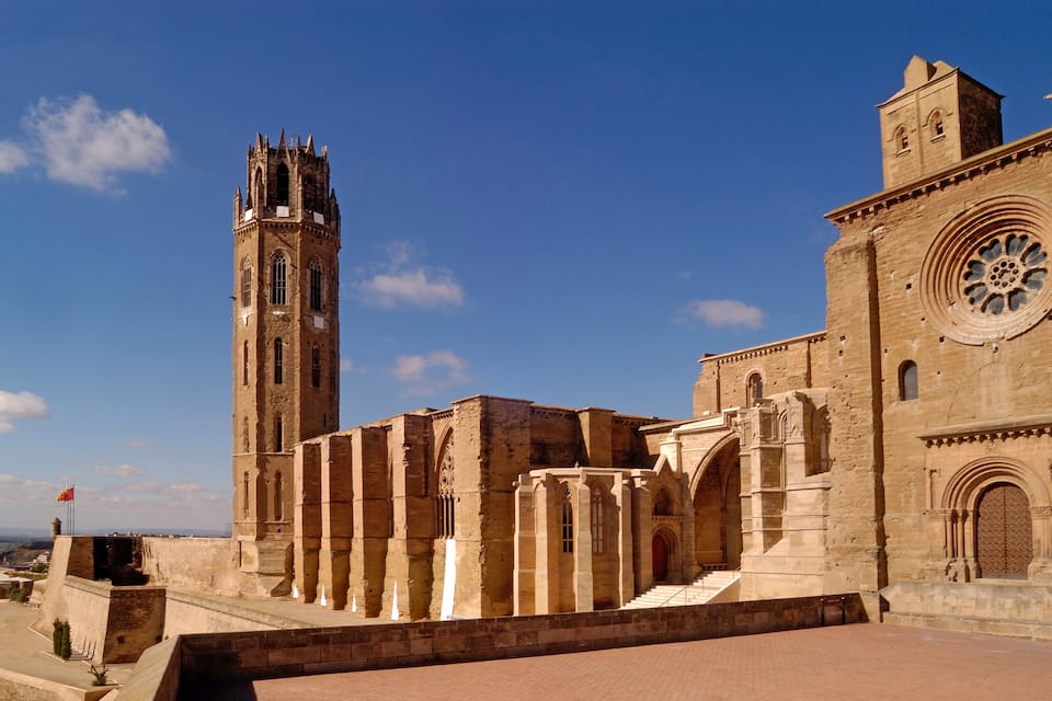 Una cattedrale storica con un campanile slanciato e un’ampia finestra circolare.