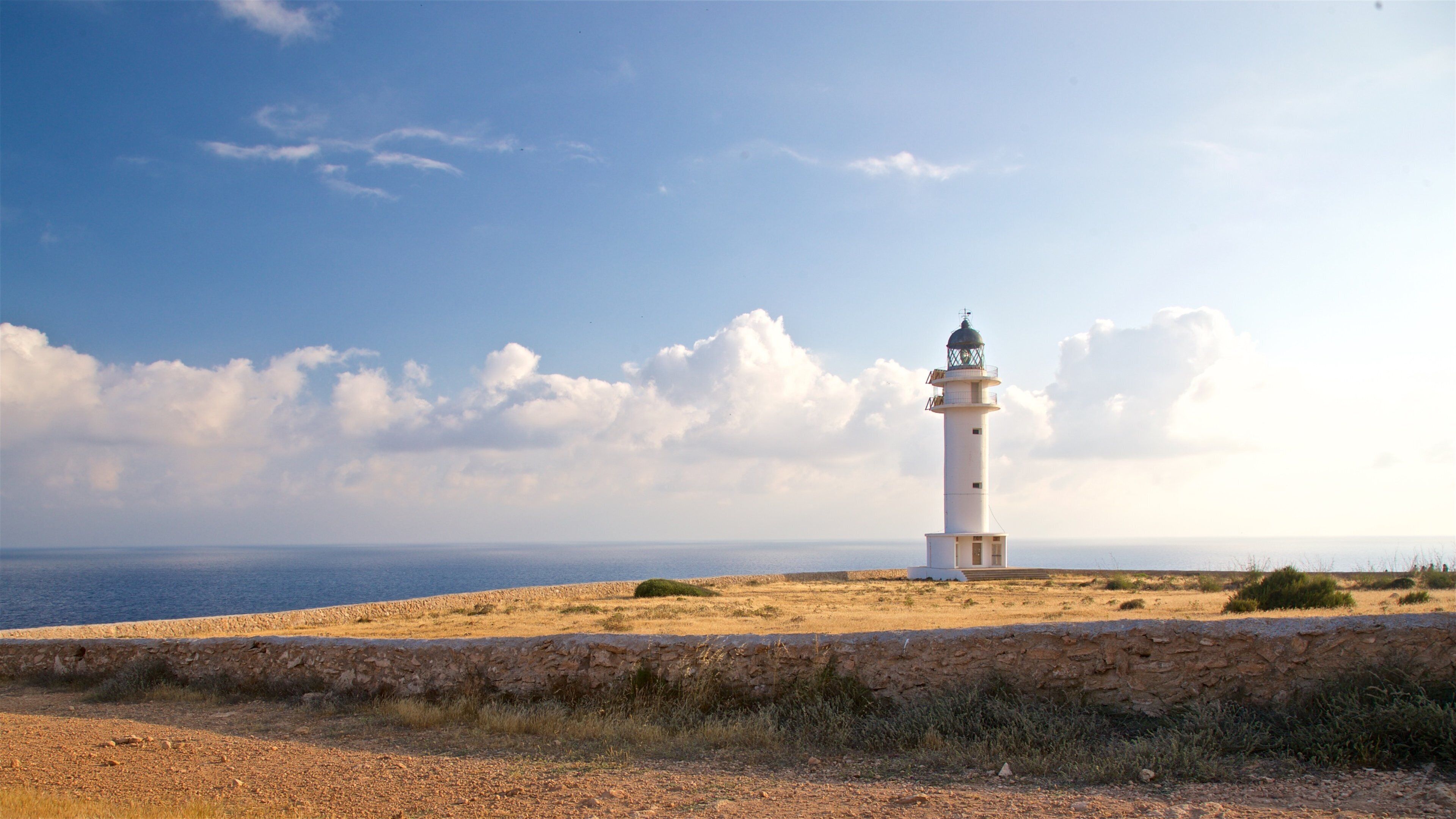 Cap de Barbaria Lighthouse showing a lighthouse, a sunset and general coastal views