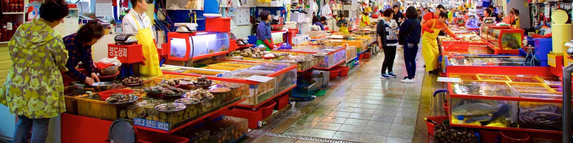 Jagalchi Fish Market showing interior views and shopping as well as a small group of people