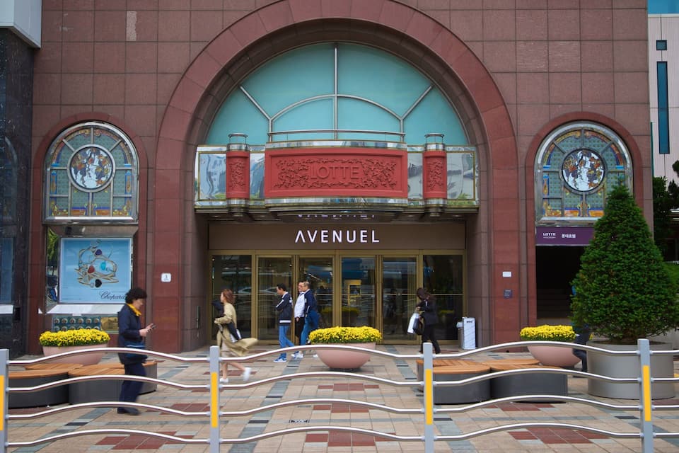 Un edificio con fachada roja, amplios ventanales y el nombre 'AVENUEL' en la entrada.