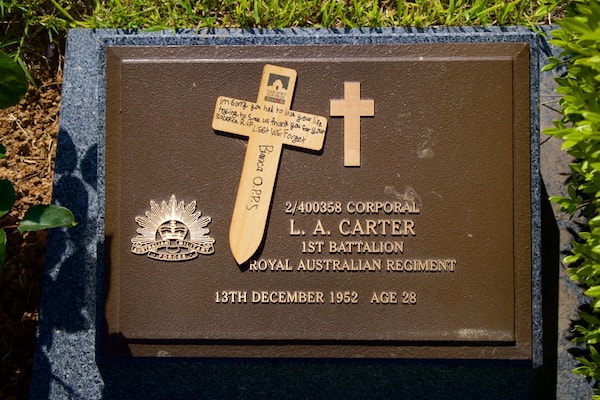 Eine Gedenktafel mit einem Kreuz, Inschriften und dem australischen Militärwappen.