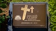 Eine Gedenktafel mit einem Kreuz, Inschriften und dem australischen Militärwappen.