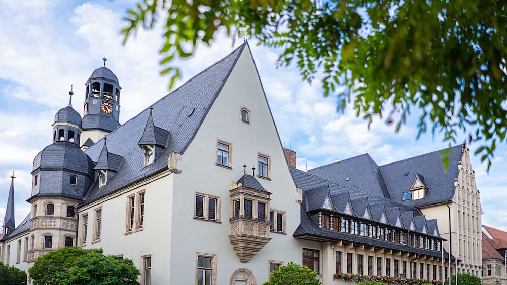 A historic building with multiple towers and a steeply pitched roof.
