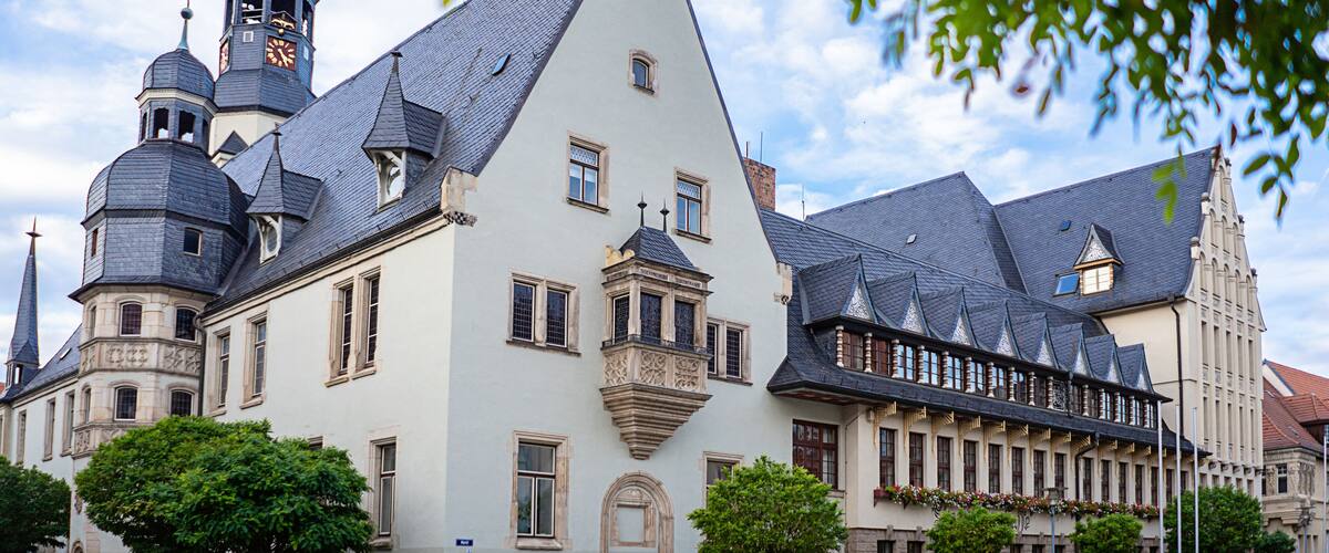 A historic building with multiple towers and a steeply pitched roof.