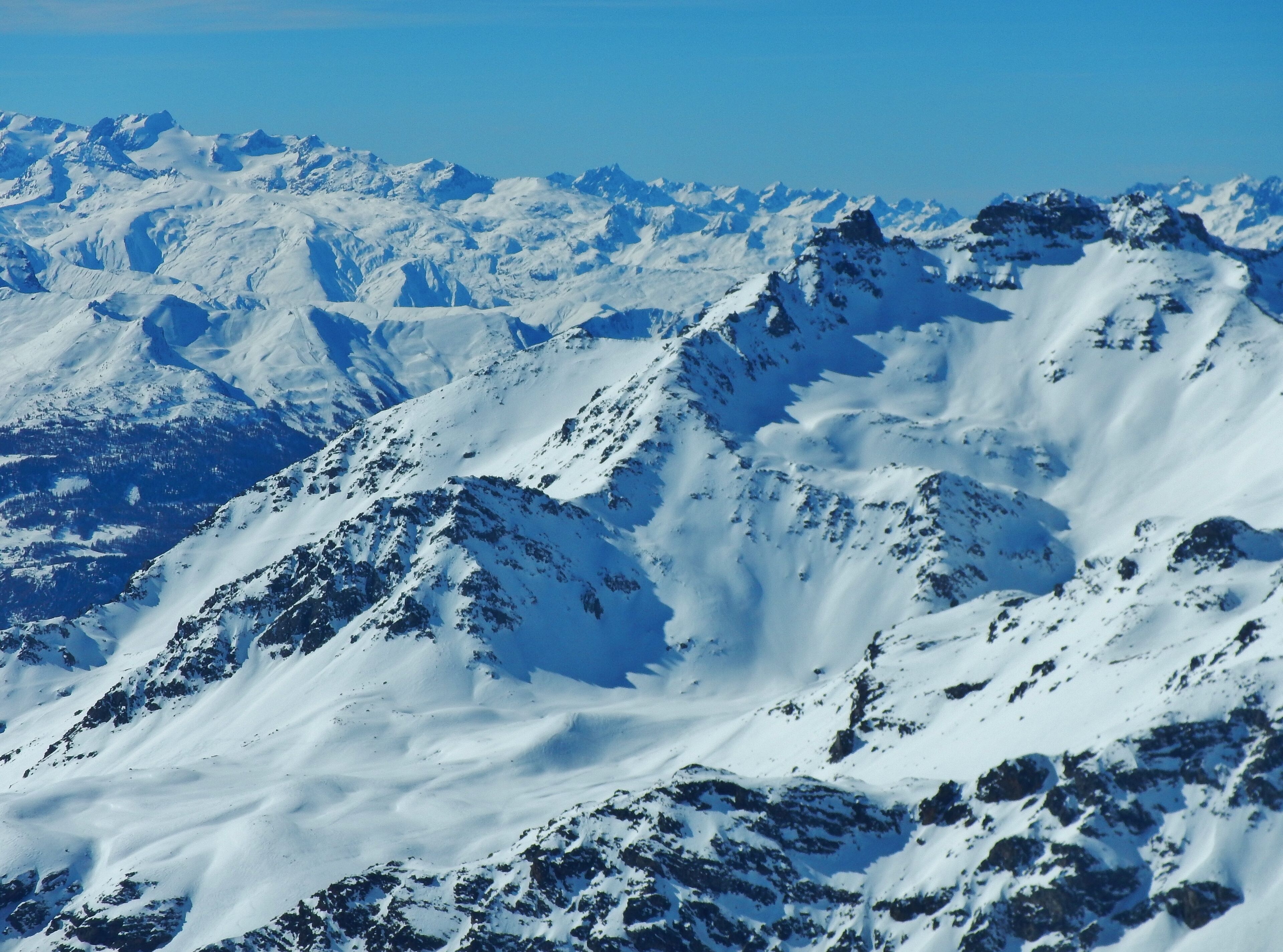 A snow-covered mountain range with rugged peaks and deep valleys.