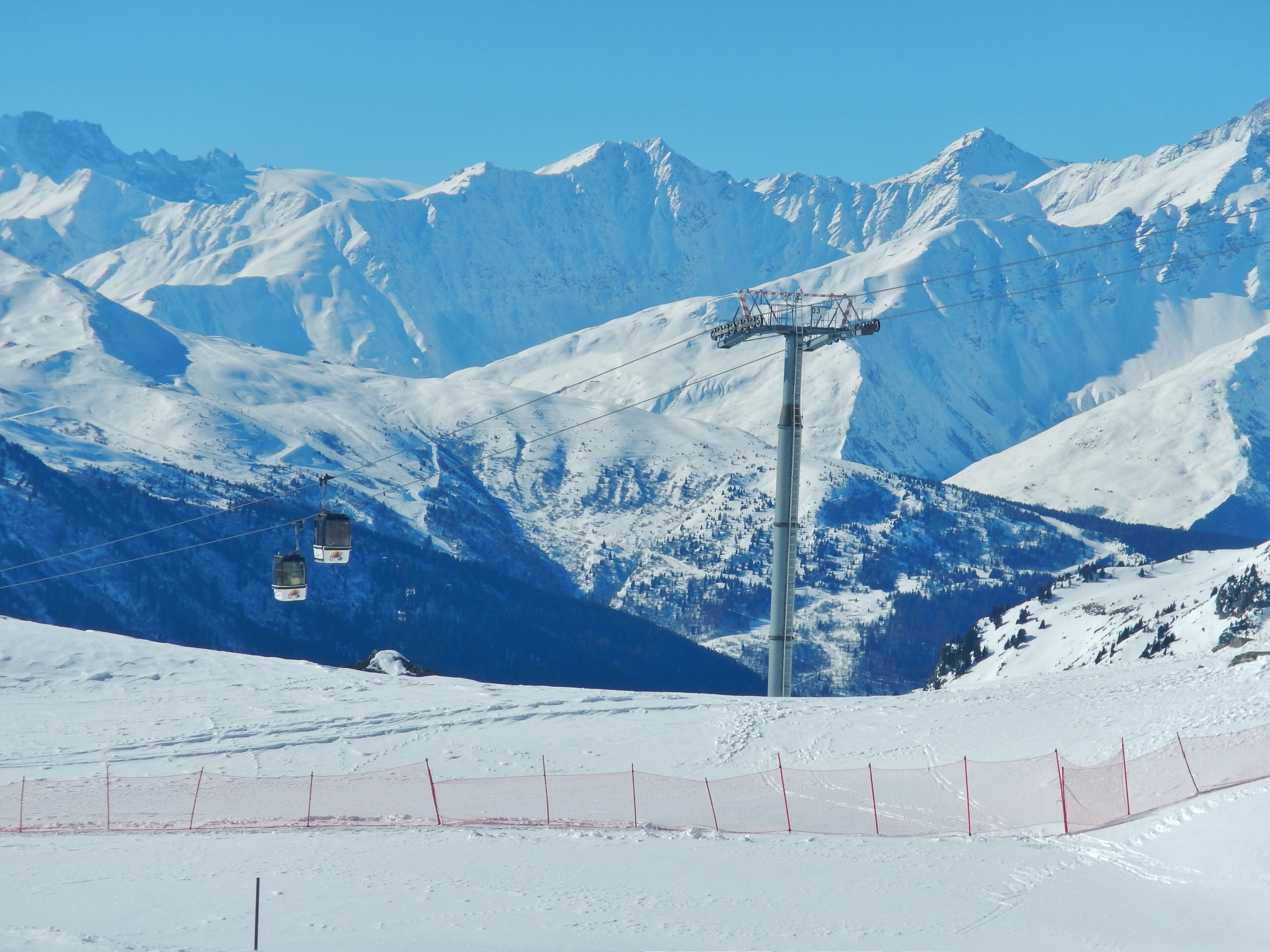 A snow-covered mountain with a ski lift and a clear blue sky.