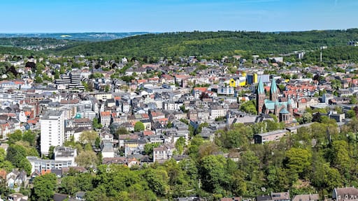 A densely populated city with a mix of modern and traditional architecture, surrounded by lush green hills.