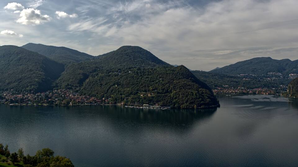 A lake surrounded by mountains with a small town on the shore.