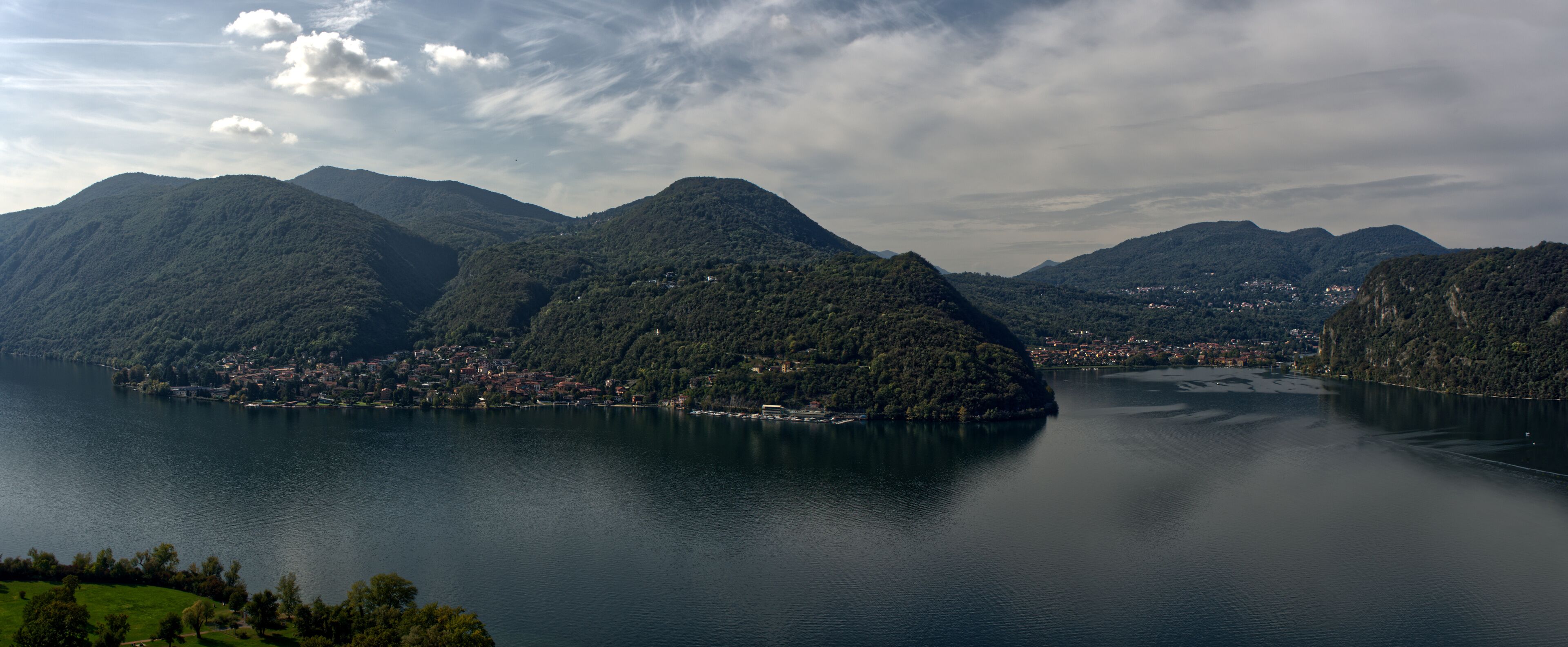 A lake surrounded by mountains with a small town on the shore.