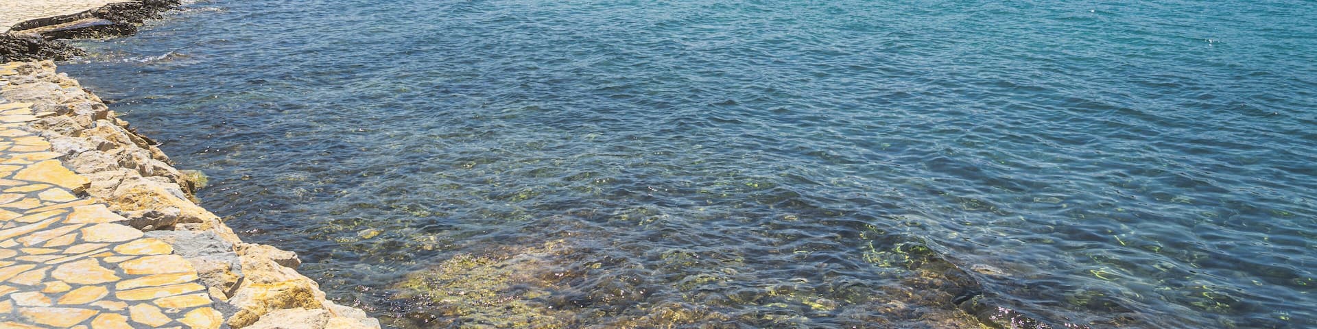 People relaxing in clear waters of Zaton bay with rocky coastline. Families having fun in turquoise water of Adriatic Sea at sunny day, Croatia